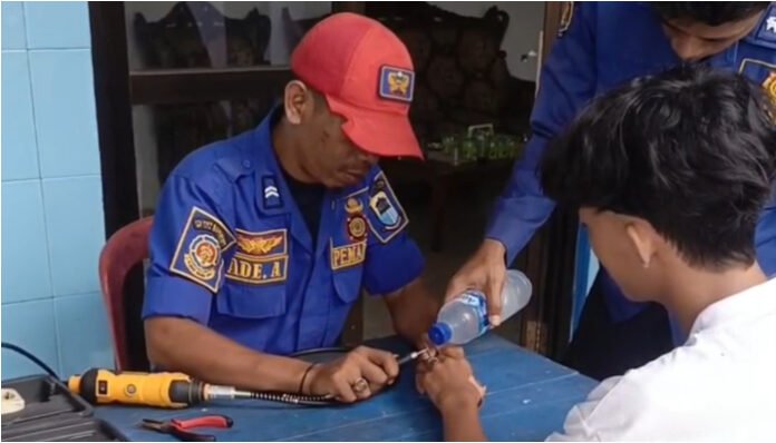 Petugas Damkar sedang membantu melepas cincin yang tersangkut dari jari seorang pelajar asal Panggarangan, Bayah Kabupaten Lebak.