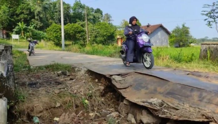 Seorang pengendara motor nekat melintasi jembatan rusak di Kampung Pasir Koer, Desa Kubang Kondang, Kecamatan Cisata, Pandeglang, Banten.