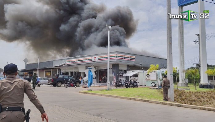 Petugas keamanan berusaha mengamankan lokasi saat kobaran api dan asap pekat membubung dari sebuah gerai 7-Eleven yang terbakar hebat di Thailand, Jumat 26 Juli 2025.