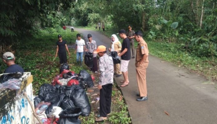 Warga dan aparatur Kecamatan Pamarayan bersama-sama membersihkan tumpukan sampah di pinggir jalan dalam aksi 