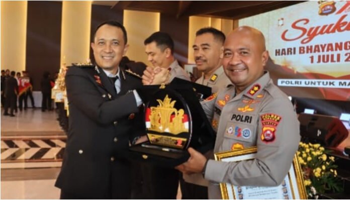 Karo SDM Kombes M Darwis Debby Hermawan mewakili Kapolda Banten Irjen Suyudi Ario Seto, menyerahkan penghargaan dan trophy juara umum kepada Kapolres Serang AKBP Condro Sasongko di gedung Serba Guna Mapolda Banten, Selasa 1 Juli 2025. (Foto: Banten TV)