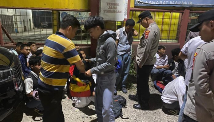 Petugas Polsek Cikande melakukan pemeriksaan terhadap sejumlah pelajar yang diamankan saat nongkrong malam hari di pinggir Jalan Raya Serang–Tangerang.