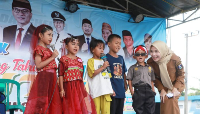 Bupati Serang Ratu Rachmatuzakiyah tampak akrab bersama anak-anak saat menyaksikan penampilan mereka di panggung perayaan HUT ke-46 Desa Sindangheula, Kecamatan Pabuaran, Senin, 28 Juli 2025.