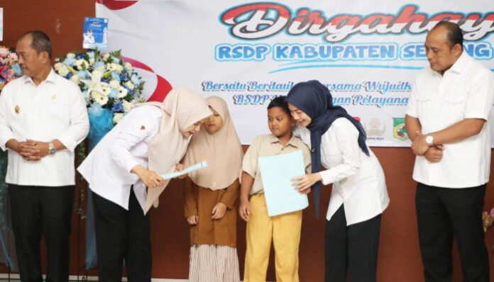 Bupati Serang Ratu Rachmatuzakiyah menyerahkan santunan kepada anak yatim saat peringatan HUT ke-87 RSDP Serang, Rabu 20 Agustus 2025.