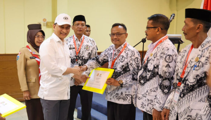 Wakil Gubernur Banten Dimyati Natakusumah menyerahkan piagam kepada pengurus PGRI Pandeglang dalam Rapimkab I Tahun 2025, Rabu 27 Agustus 2025.