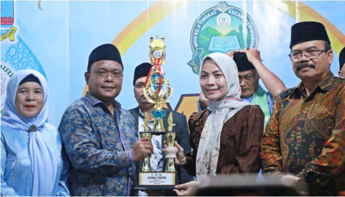 Bupati Serang Ratu Rachmatuzakiyah menyerahkan piala juara umum kepada perwakilan Desa Labuan pada ajang MTQ ke-III tingkat Kecamatan Mancak, Selasa 5 Agustus 2025.
