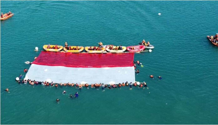 Relawan Gabungan Kibarkan Bendera Raksasa di Laut Merak, Wujudkan Penghormatan pada Laut sebagai Sumber Kehidupan (Foto _ Dok.Banten.com)