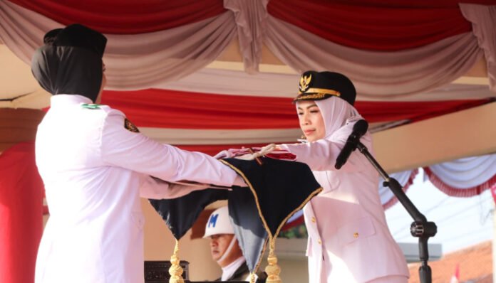 Bupati Serang Ratu Rachmatuzakiyah menyerahkan bendera Merah Putih dari pasukan Paskibraka pada upacara peringatan HUT ke-80 RI di Alun-alun Kramatwatu, Minggu 17 Agustus 2025.