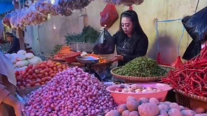 Seorang pedagang sayur mayur termasuk cabai, tengah melayani pembeli di kiosnya (Bantentv.com/ Nano)