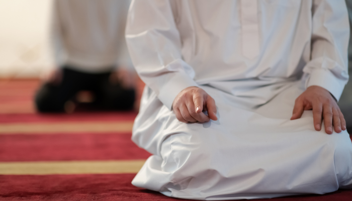 Ilustrasi seorang muslim sedang salat dalam posisi tahiyah (dotshock)