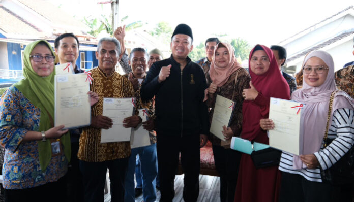 Menteri ATR/BPN Nusron Wahid menyerahkan sertifikat tanah kepada warga.