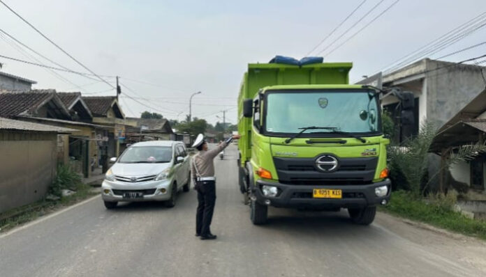 Anggota Satlantas Polres Serang, memberhentikan truk tambang yang melanggar aturan operasional.
