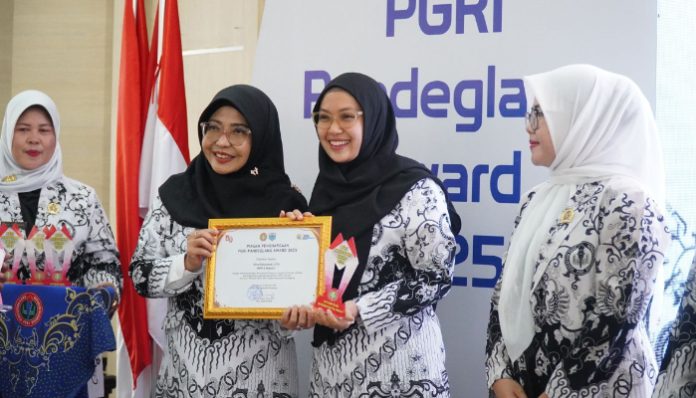 Bupati Pandeglang Raden Dewi Setiani menyerahkan penghargaan di acara Penganugerahan PGRI Pandeglang Award 2025. (Foto: Istimewa)