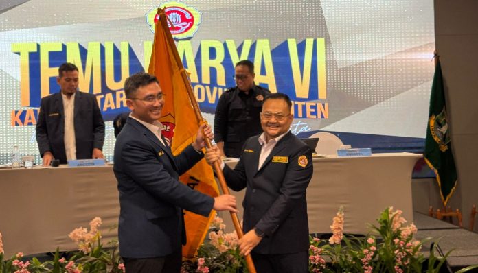 Andika Hazrumy (kiri) menyerahkan bendera Karang Taruna kepada Yudi Budi Wibowo (kanan) Ketua terpilih Karang Taruna Banten periode 2025-2030. (Foto: Istimewa)