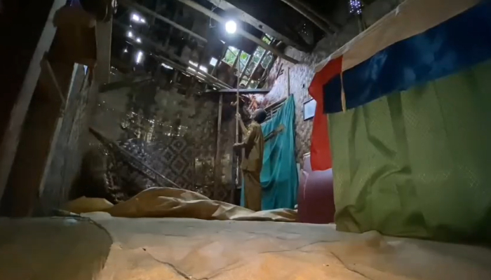 Cacang Hidayat memeriksa atap rumahnya yang nyaris roboh. (Foto: Bantentv.com)