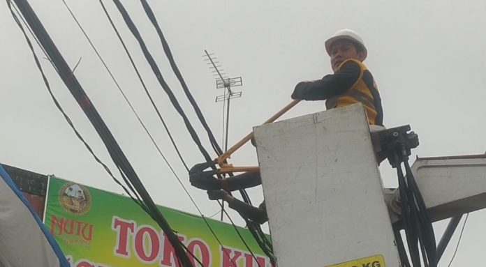 Nur Agis menggunting kabel provider semrawut di Royal Baroe (Bantentv.com/ Jaya)