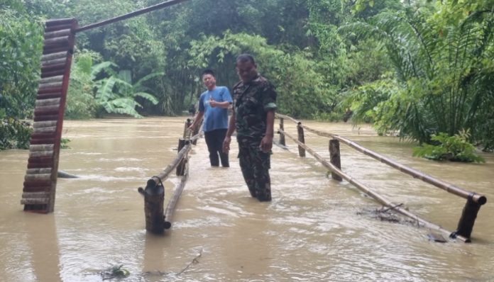 Anggota TNI dari Babinsa Koramil 0116/Cikeusik, Kodim 0601/Pandeglang, Sertu Eri Piatna tengah melakukan monitiring kondisi banjir di wilayahnya (Bantentv.com/ Rangga)