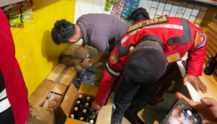 Anggota Polisi menyita ratusan botol minuman keras illegal dari kios jamu. (Foto: Bantentv.com)