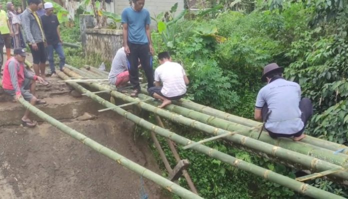 Warga Desa Sinar Jaya bersama-sama membangun jembatan darurat secara swadaya menggunakan material bambu