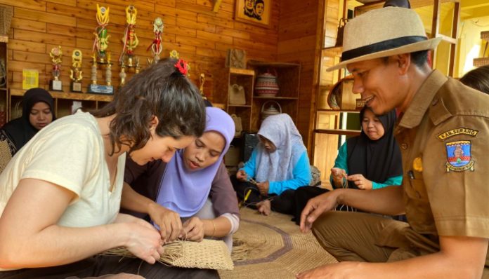 Turis asal Swedia, Sofia sedang mempelajari proses pembuatan kerajinan anyaman bambu yang dikembangkan masyarakat desa Tegal Maja, Kabupaten Serang.