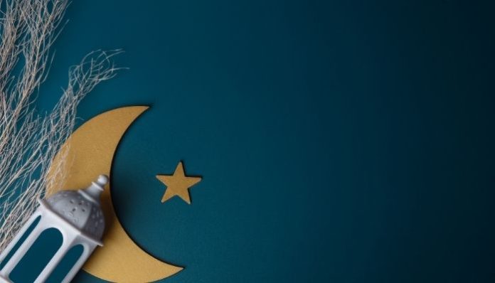 Ilustrasi ornamen Ramadan berupa bulan sabit, bintang, dan lentera di latar biru.