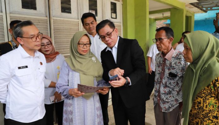 Kepala Kanwil BPN Provinsi Banten Harison Mocodompis saat menunjukan cara mengecek sertipikat tanah, melalui aplikasi Sentuh Tanahku.