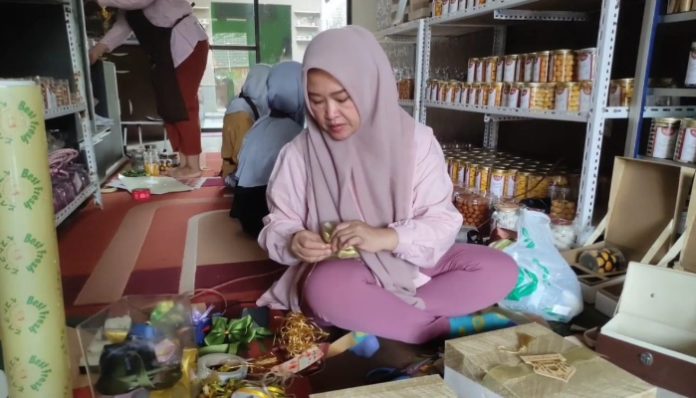 Reni Agustiani sedang menyiapkan hampers Lebaran di rumah produksinya