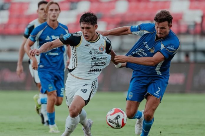 Pemain Persija Jakarta dan PSIM Yogyakarta berebut bola dalam laga yang berakhir imbang 1-1