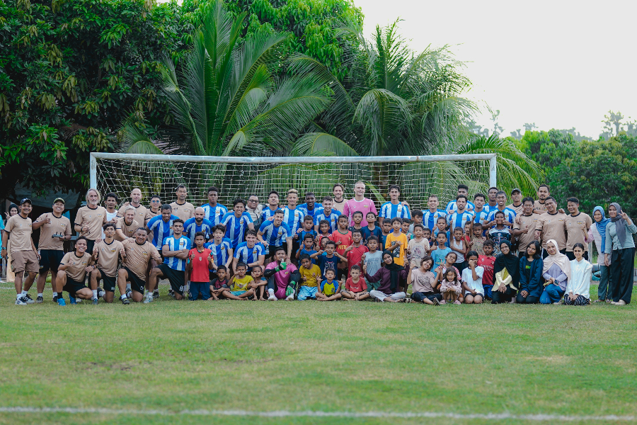 Tim Dewa United foto bersama anak-anak dan warga usai menjalani sesi latihan jelang laga kontra Malut United