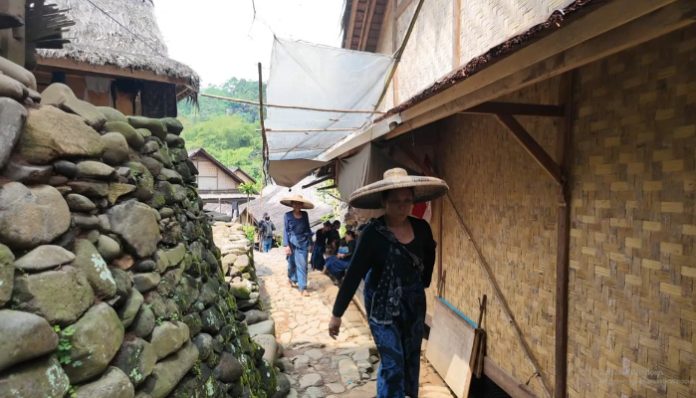 Warga adat Baduy berjalan menyusuri jalan setapak di kawasan Desa Kanekes, Lebak, Banten