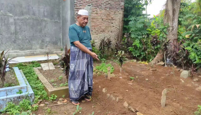 Keluarga korban menunjukkan makam korban pengeroyokan