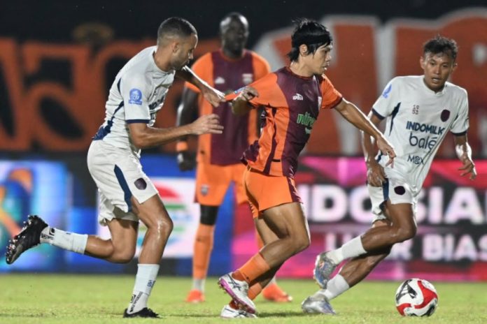 Pemain Borneo FC mendapat gangguan dari pemain Persita saat menggiring bola dalam pertandingan di Stadion Segiri