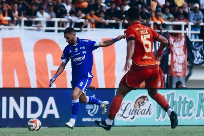 Pemain Persib Bandung membawa bola di bawah kawalan ketat pemain Persija Jakarta