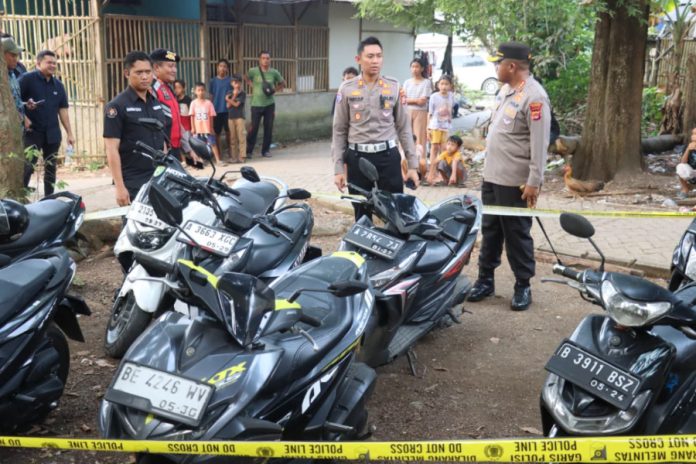 Petugas kepolisian memasang garis polisi usai menggerebek arena yang diduga digunakan untuk perjudian sabung ayam di Kabupaten Tangerang