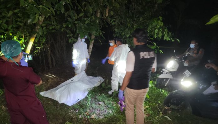 Petugas kepolisian mengevakuasi jasad perempuan yang ditemukan tergantung di area kebun melinjo