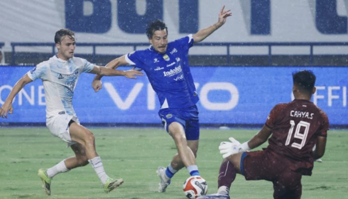 Thom Haye menggiring bola sambil mencoba melewati hadangan pemain PSIM Yogyakarta dalam laga di Stadion GBLA