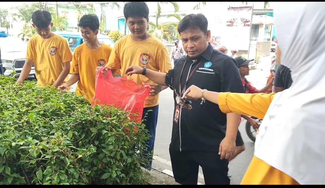 Ketua Tim Penjaminan Mutu Balai Penjaminan Mutu Pendidikan (BPMP) Provinsi Banten ikut membersihkan lingkungan bersama sejumlah pelajar (Foto: Bantentv.com/ Jaya)