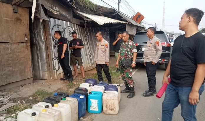 Personel Polsek Cikande Polres Serang mengamankan ratusan liter minuman di wilayah Kecamatan Kibin, Kabupaten Serang (Foto: Bantentv.com/ Imron)