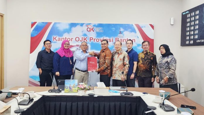 Kepala OJK Provinsi Banten, Adi Dharma saat menyerahkan SK Pemberian Izin Penggabungan PT Bank Perekonomian Rakyat Difobutama ke dalam PT Bank Perekonomian Rakyat Marcorindo Perdana